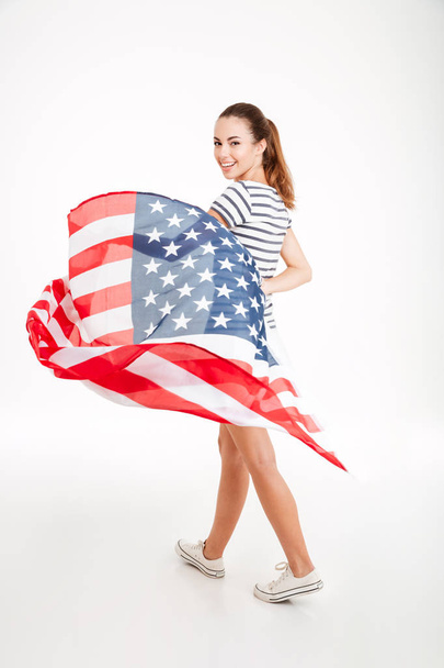 Happy young woman walking and holding usa flag - Foto, Imagem