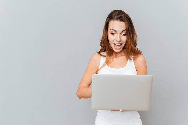 Portrait of surprised woman with laptop - Φωτογραφία, εικόνα