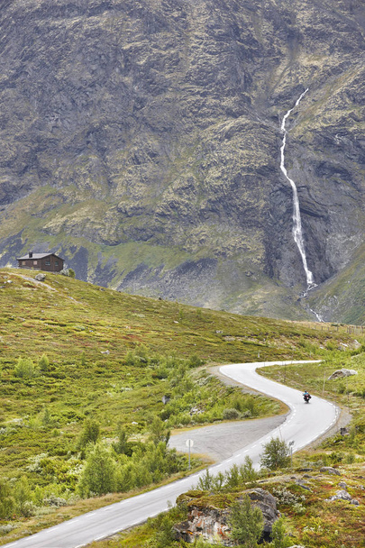 Norwegian mountain road landscape. Waterfall and cabin. Motorcyc - Photo, image
