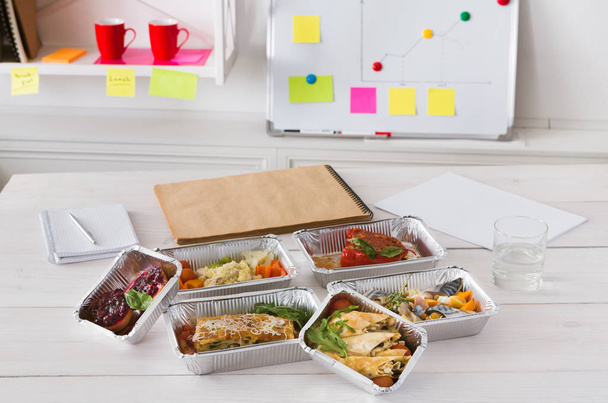 Healthy lunch foil box with diet food on office table - Φωτογραφία, εικόνα