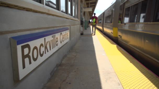 Berufspendler am Rockville-Center-Zug vorbei am Bahnhofsschild - Filmmaterial, Video
