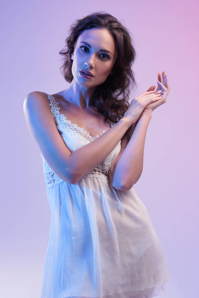 Όμορφη γυναίκα με λευκό φόρεμα και μπλε φως  - Φωτογραφία, εικόνα