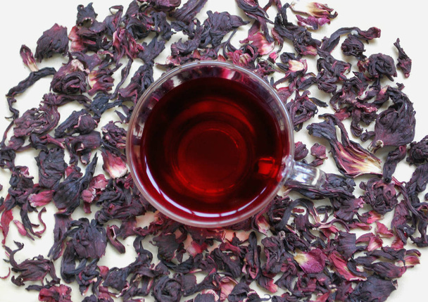 egy csésze vörös tea a háttérben a Hibiscus. - Fotó, kép