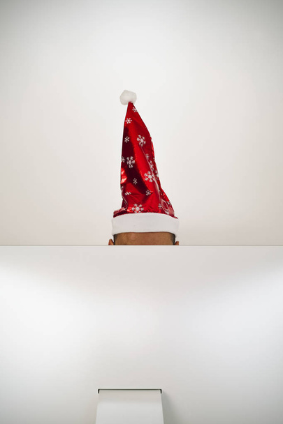 человек с шляпу Санта в своем кабинете - Фото, изображение