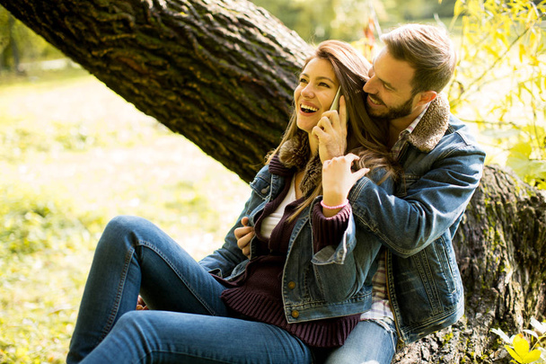 Couple avec téléphone dans le parc d'automne
 - Photo, image