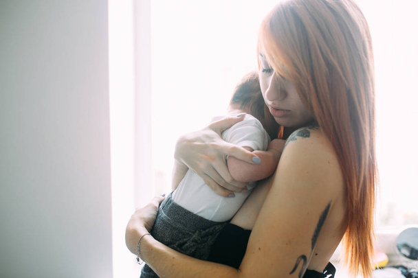 Joven madre mujer sosteniendo a su hijo bebé - Foto, Imagen