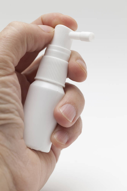 hand with white spray bottle - Фото, изображение