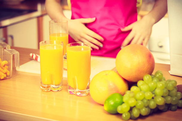 Woman with fresh fruits and juice in kitchen - Foto, immagini
