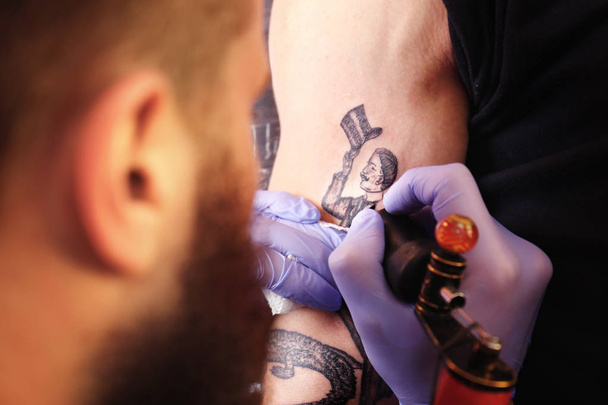 Professional artist making tattoo in salon, close up view - Фото, изображение