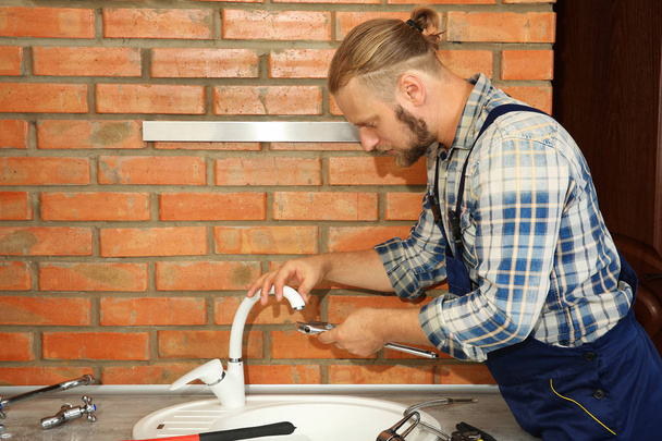Handsome plumber repairing  - Fotó, kép