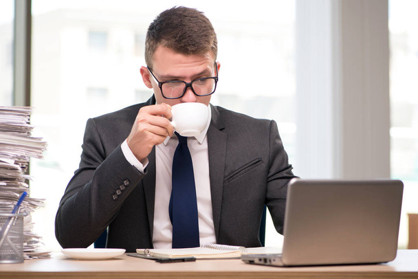 Young businessman drinking tea in the office - Foto, afbeelding