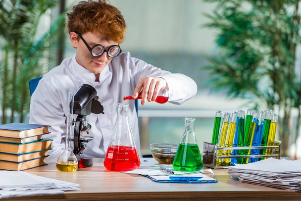 junger verrückter Chemiker arbeitet im Labor - Foto, Bild
