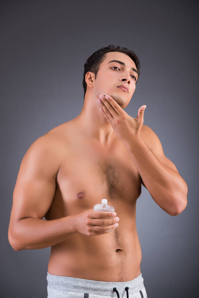 Handsome man applying aftershave afer shaving - Valokuva, kuva