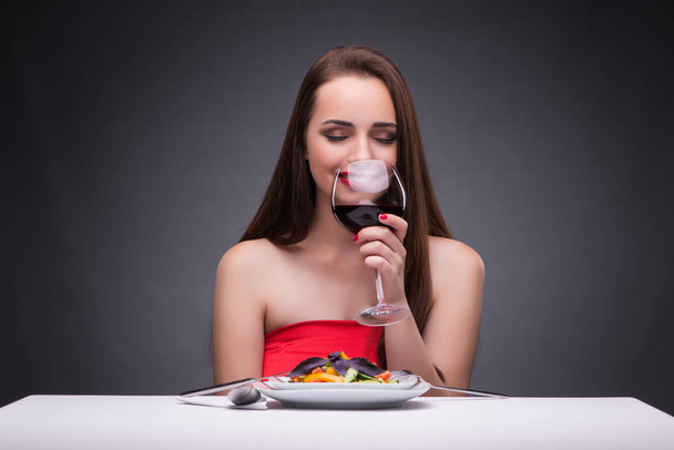 Beautiful woman eating alone with wine - Foto, Imagen