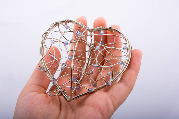 Клетка в форме сердца в руке
 - Фото, изображение