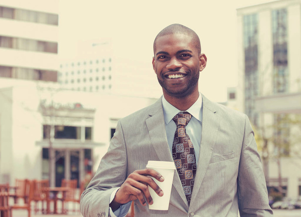 young man with coffee cup smiling - Fotó, kép