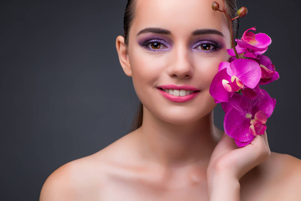 Mulher bonita nova com flor do orchid
 - Foto, Imagem