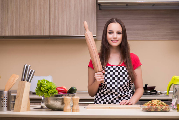 Jeune femme au foyer travaillant dans la cuisine
 - Photo, image