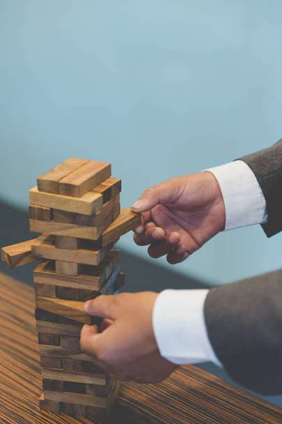 businessman gambling placing wooden block on a tower - planning, - Photo, Image