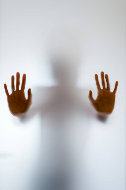 Figura humana sombria atrás de um vidro fosco
 - Foto, Imagem