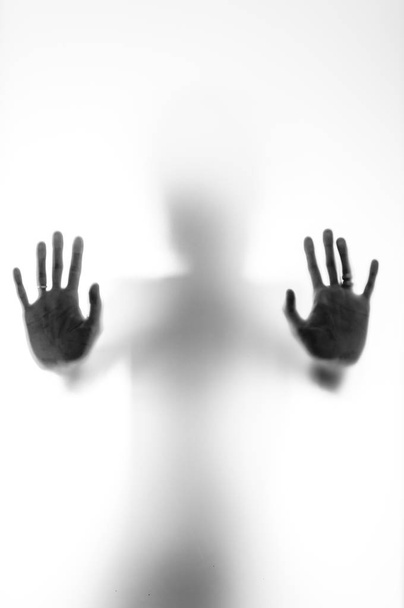 Shadowy human figure behind a frosted glass - Фото, зображення
