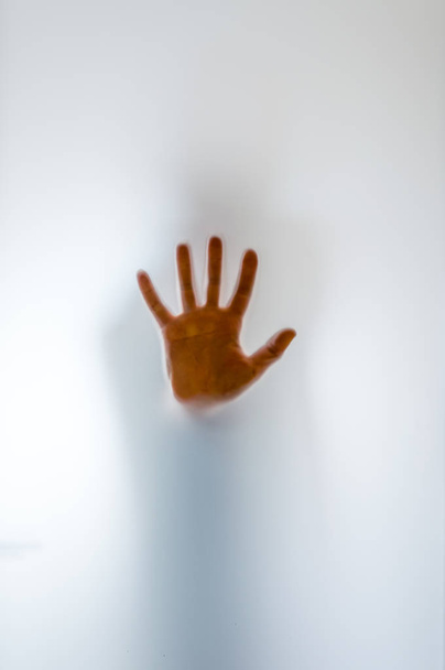 Σκιερά ανθρώπινη φιγούρα πίσω από ένα παγωμένο ποτήρι - Φωτογραφία, εικόνα
