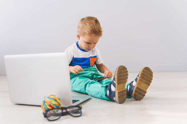 Little boy sitting with digital gadgets in studio - Photo, image