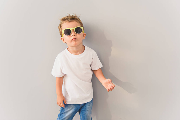 Menino de óculos de sol posando em estúdio
 - Foto, Imagem