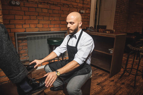 bald bearded man preparing to shoe shine - Foto, imagen