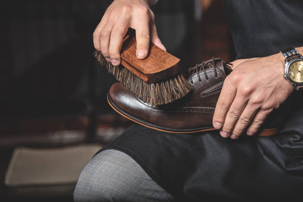 brush in hands of man cleaning shoes - 写真・画像