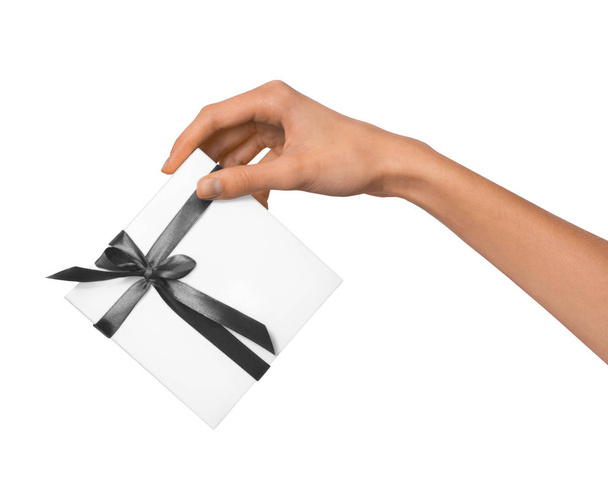 Женщина держит в руках праздничный подарок белый ящик с серой лентой
 - Фото, изображение
