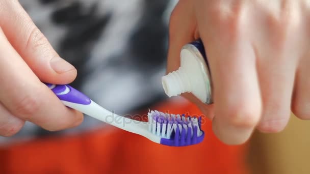 мужчина сжимает зубную пасту на щетке
 - Кадры, видео