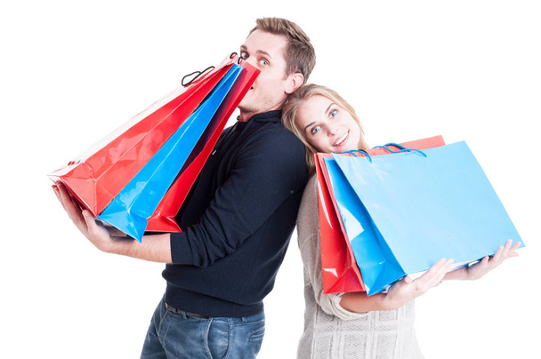 feliz casal segurando pesados sacos de compras e agindo brincalhão
 - Foto, Imagem