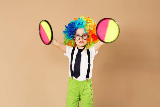 Ragazzo in parrucca clown e occhiali che gioca palla gioco cattura
 - Foto, immagini