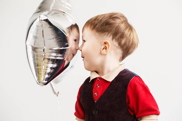 Rapaz a sorrir e a tocar o macaco com balões em forma de estrela
  - Foto, Imagem