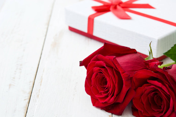 Caja de regalo blanca y rosas en madera blanca table.copyspace
 - Foto, Imagen