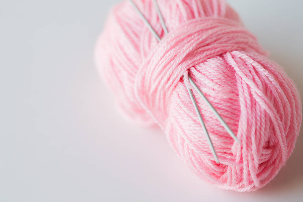 knitting needles and ball of pink yarn - 写真・画像