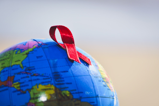 παγκόσμια σφαίρα με μια κόκκινη κορδέλα για την καταπολέμηση του Aids - Φωτογραφία, εικόνα