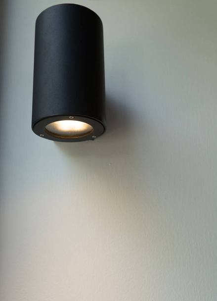 Black wall lamp on white wall. - Foto, afbeelding