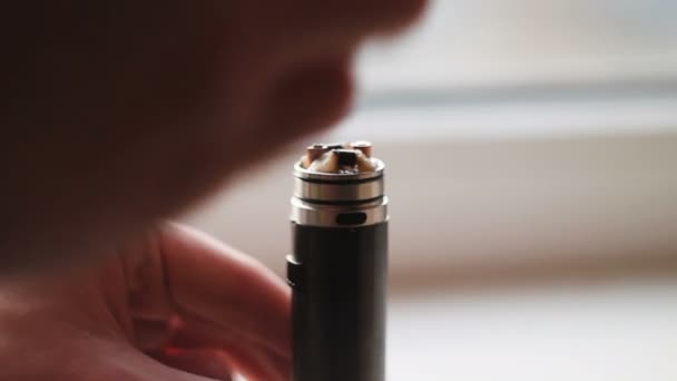 Man filling an electronic cigarette with e-juice. Man detaching the reservoir tank from the atomizer and battery to fill it with flavored liquid e-juice that may or may not contain nicotine. - Footage, Video
