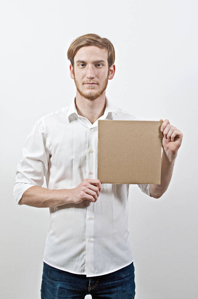 Young Adult Man in White Shirt Holding a Cardboard Inscription - Photo, Image
