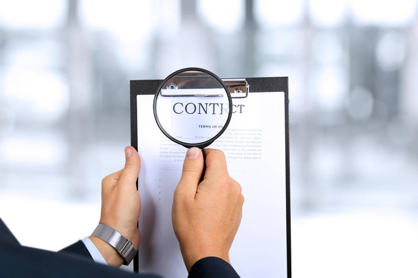 man looking through a  magnifying glass  to the Blank of contract - Foto, imagen