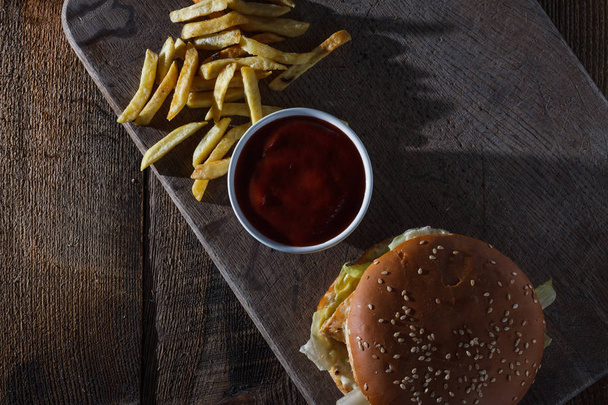 Juicy beef burger and french fries on wooden board with blank sp - Foto, immagini