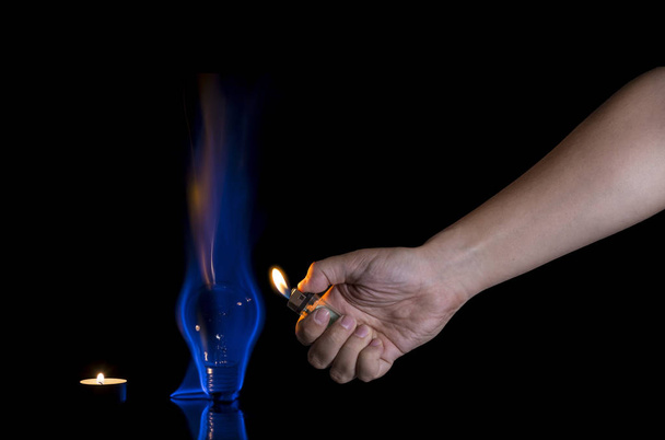 Hand lighting a lightbulb instead a candle - Φωτογραφία, εικόνα