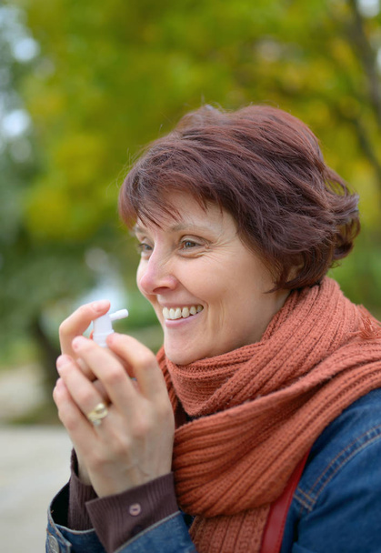 Frau setzt Kehlkopfspray ein - Foto, Bild