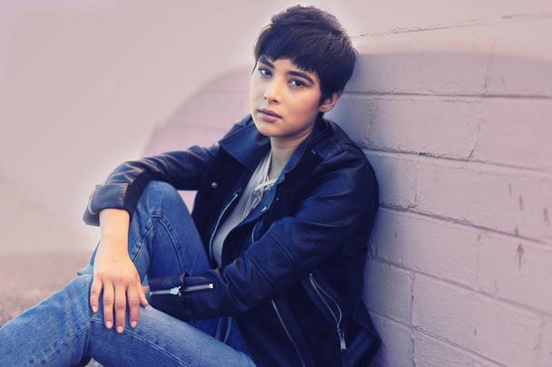 Young woman with short hair sitting wearing leather jacket - Φωτογραφία, εικόνα