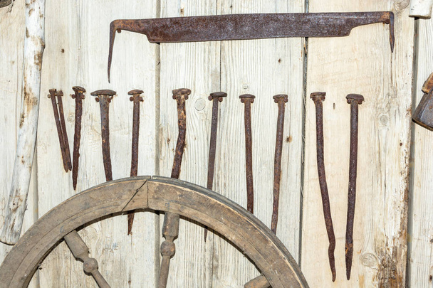 Ancient iron products on the background of wooden wall.  - Foto, afbeelding