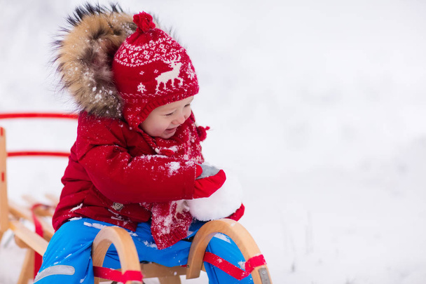 子供たちは雪の中で遊ぶ。子供のための冬そり - 写真・画像