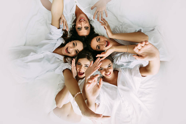 Positive bridesmaids and a bride in the light room - Photo, Image