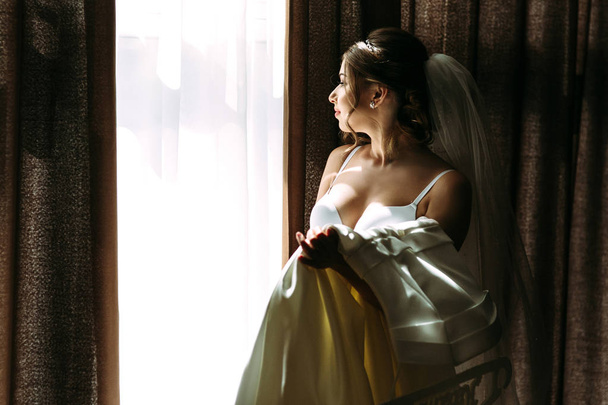 Young bride is holding her bridal dress - Foto, Bild